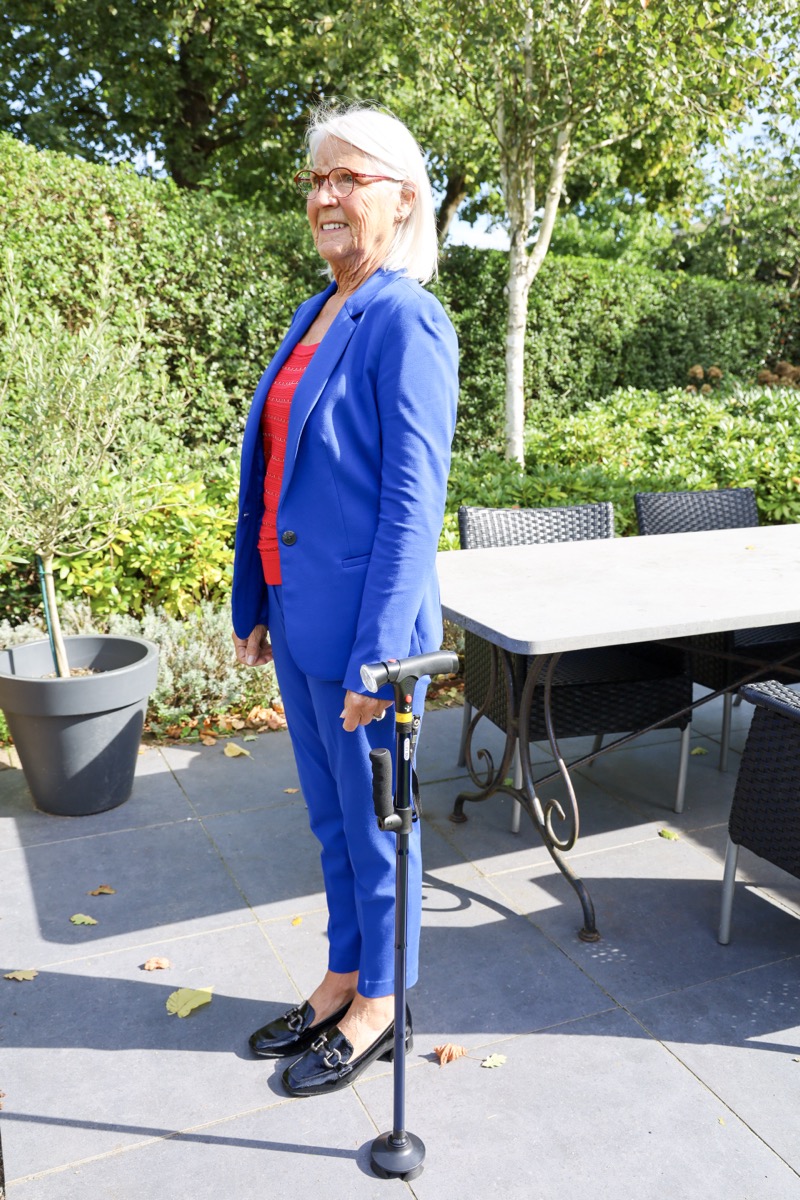 Senior s vychádzkovou palicou DR-HO'S Get Up & Go pri istej chôdzi vonku